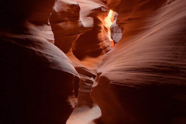 Narrow sandstone canyon with light streaming through.
